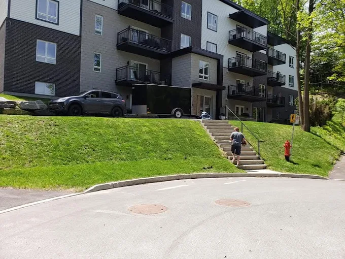 Talus gazonné entretenu devant un immeuble à logements